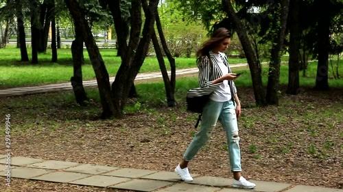 young girl walks in the park in summer clothes