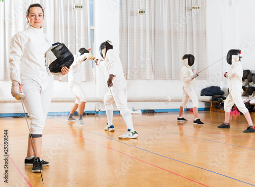 Female fencer standing in gym