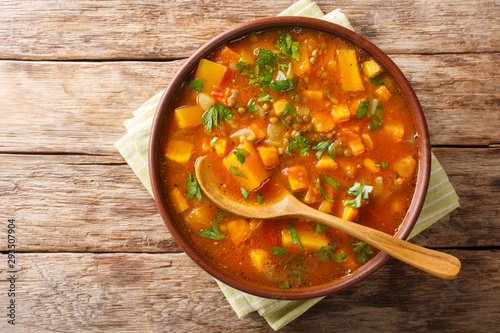 Traditional thick sweet potato soup with lentils close up in a bowl on the table. Horizontal top view