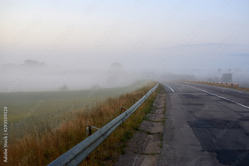 Fog on the ukrainian road. The end of the patched road and the beginning of the road with new asphalt.