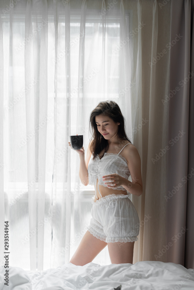 Asian women while reading book near window with shear curtain / bedroom concept / copy space Asian women while reading book near window with shear curtain / bedroom concept / copy space