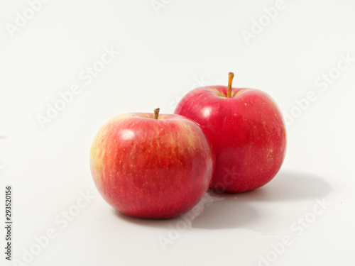 yellow autumn leaves with red apples on a white background