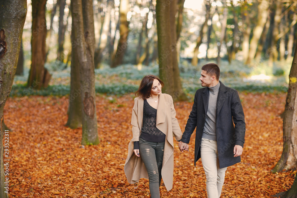 lovely couple walking around the park during autumn
