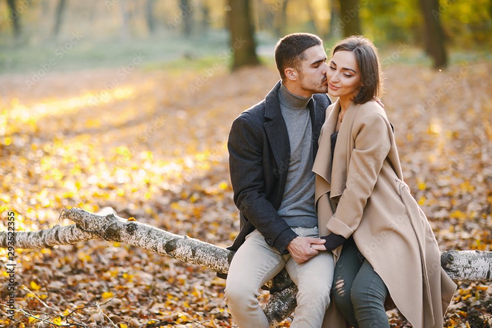 lovely couple wsitting in the park during autumn