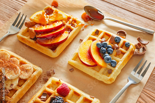 Fototapeta Naklejka Na Ścianę i Meble -  Tasty waffles with fruits and berries on wooden background