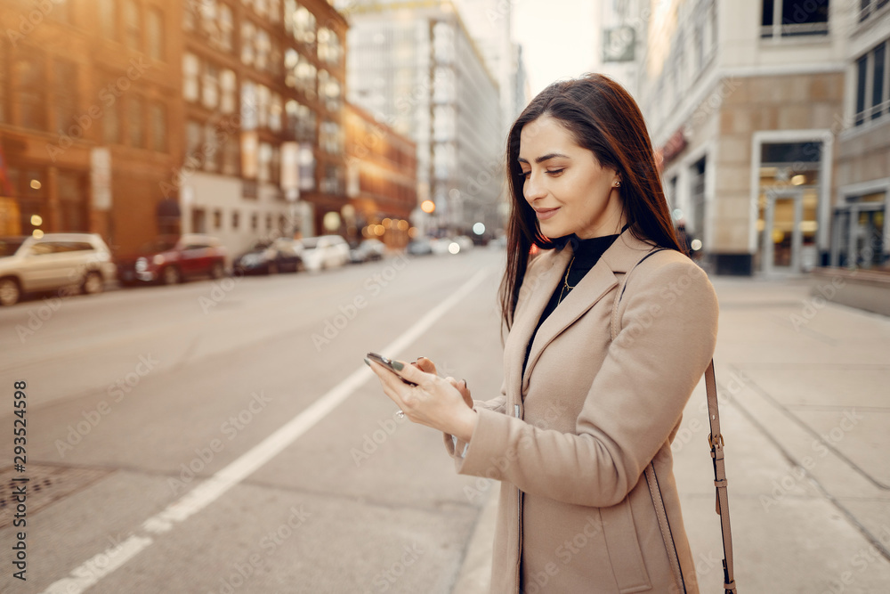 Beautiful girl in a city. Stylish brunette in a brown coat. Woman in a Chicago. Lady with a phone Beautiful girl in a city. Stylish brunette in a brown coat. Woman in a Chicago. Lady with a phone