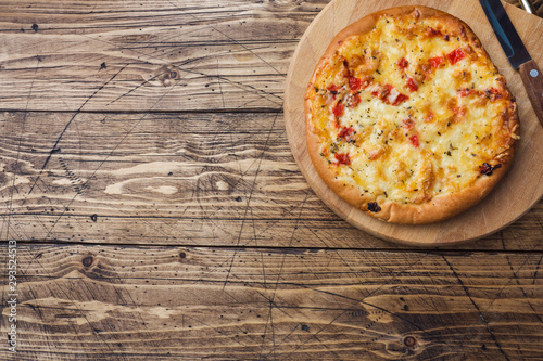 Homemade pizza tortilla with tomato and cheese on wooden background. Copy space