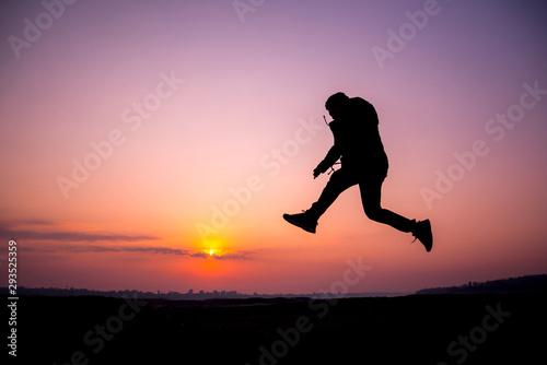 Fototapeta Naklejka Na Ścianę i Meble -  Silhouette tourists jump in the morning sunshine