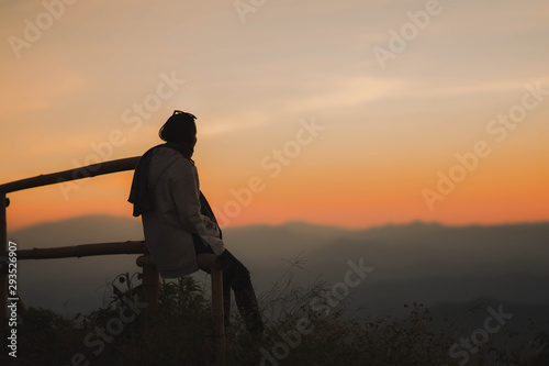 Fototapeta Naklejka Na Ścianę i Meble -  silhouette woman sitting on mountain in evening