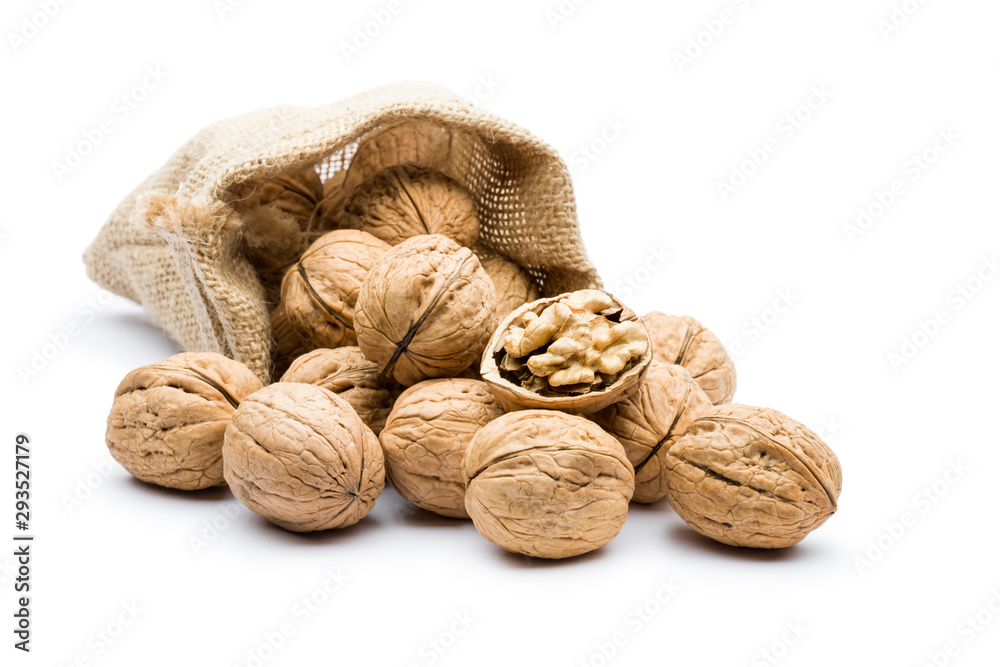pile of walnuts in juta bag on white background - obrazy, fototapety, plakaty 