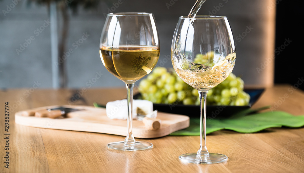 Waiter pouring white wine into wineglass. 