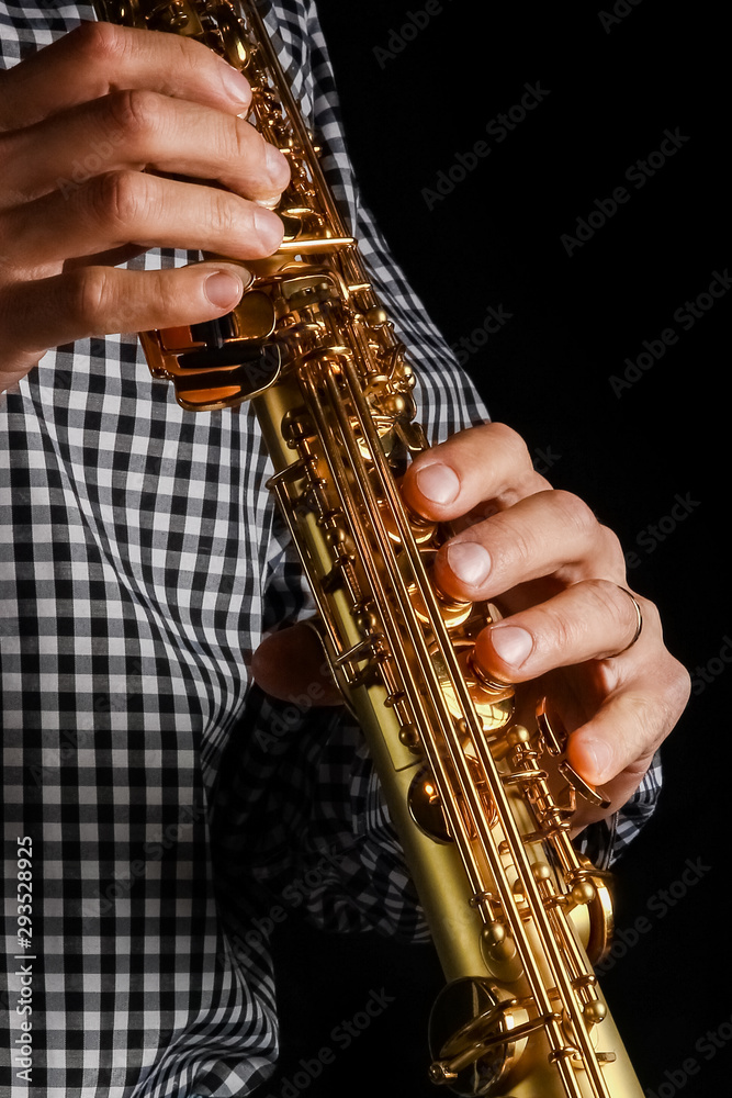 Fototapeta premium soprano saxophone in hands on a black background