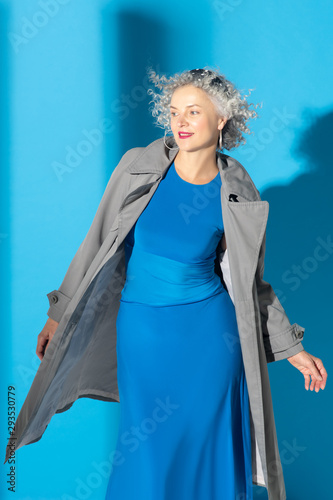 Curly grey-haired woman wearing long blue dress photo