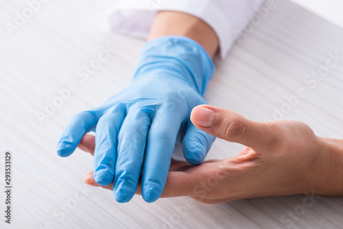 cropped view of doctor with latex glove on hand