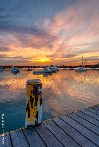 Beautiful sunset across the bay with moored yachts and boats photo