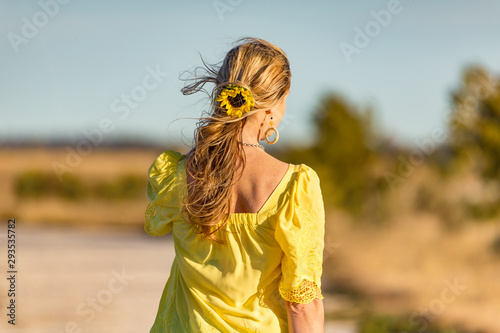 Wall Mural Woman outdoors in sunshine sunflower in her wavy hair
