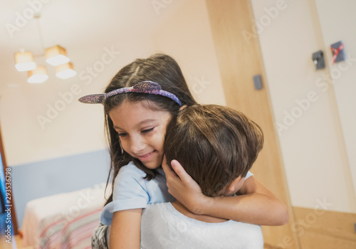 Brothers hugging in the bedroom of their house photo