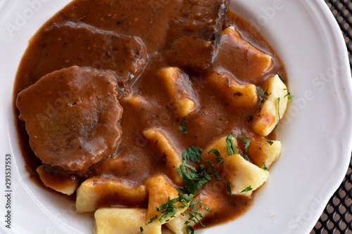 Croatian traditional cuisine, Pasticada With Gnocchi - Dalmatian Pot Roast or beef/ Croatian dish - Pasticada with gnocchi, beef stew in a sauce photo