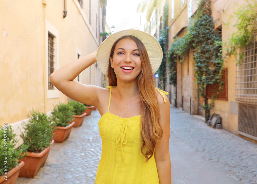Pretty girl in Trastevere, Rome. Beautiful fashion woman with yellow dress and hat walks through the streets of Rome, Italy.