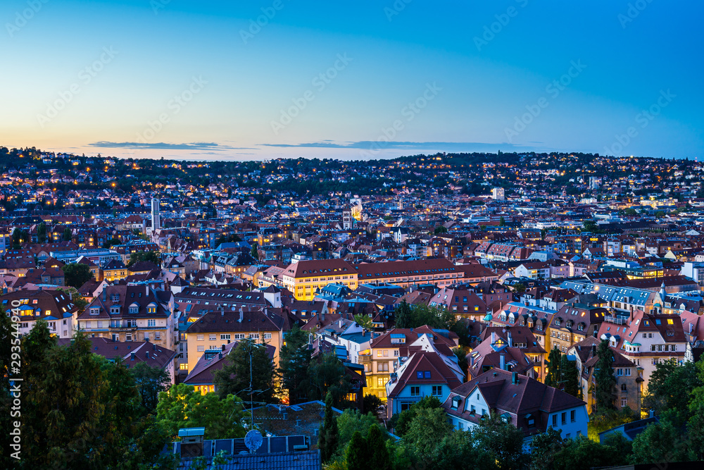 Germany, Magical summer sunset sky over urban cityscape of stuttgart city houses and roofs, aerial view from above over illuminated skyline