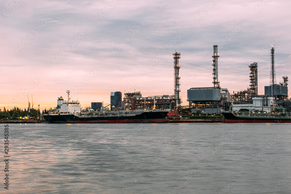 Petroleum oil refinery plant beside river in sunset time. Crude Oil Process machinery