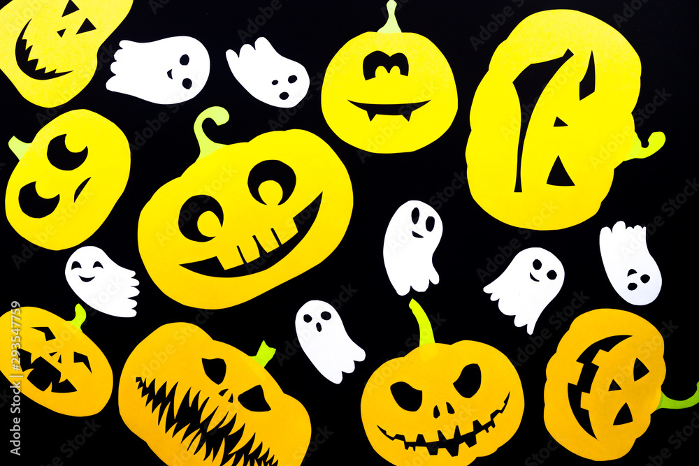 Obraz premium A colored background made of groups of pumpkins cut out of orange paper and of ghosts made of white paper isolated on a black background is ideal for the holiday of all saints - Halloween.