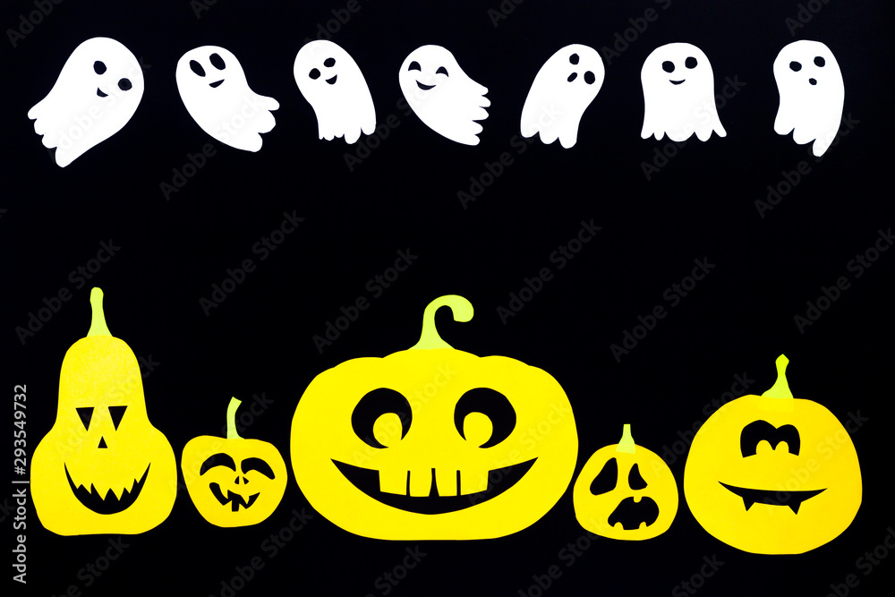 A colored background of groups of pumpkins cut out of orange paper and of ghosts made of white paper isolated on a black background with copy space, ideal for the holiday of all saints - Halloween.