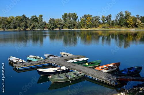 Autumn landscape with a lake, a boat bridge and some boats. photo