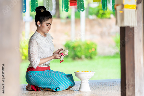 Beautiful Thai girl in traditional dress costume and Jasmine garland at Thai temple photo