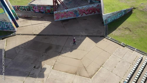 Man playing fronton tennis on a graffitied wall, public park, modern urban amphitheater. Vicente Lopez, Buenos Aires, Argentina. Aerial, drone crane shot. photo