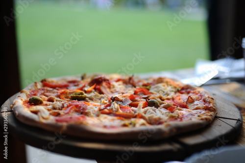 Pizza with olives on a wooden plate