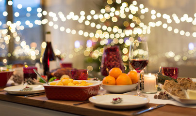 christmas dinner and eating concept - food and drinks on table at home