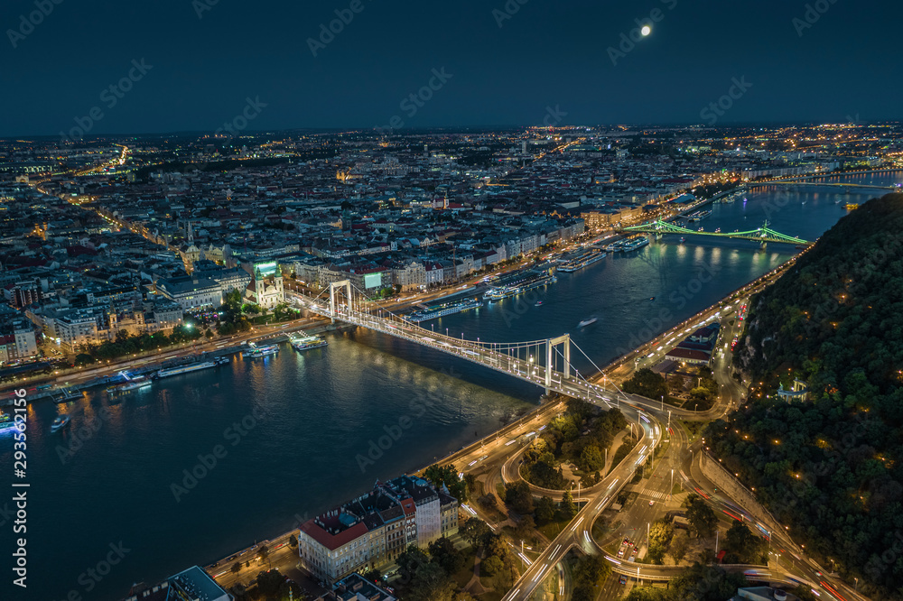 Budapest, Hungary - Aerial drone view of Budapest by night with illuminated Elisabeth and Liberty bridges, River Danube and Gellert Hill at dusk