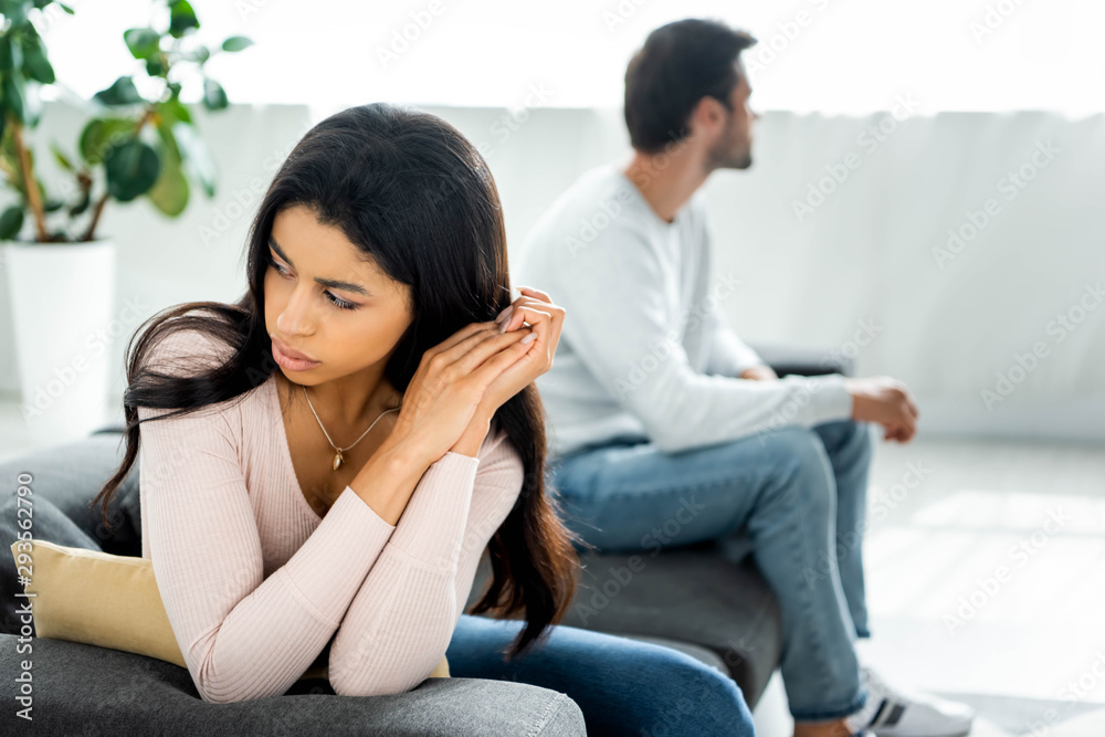 selective focus of sad african american woman sitting on sofa selective focus of sad african american woman sitting on sofa