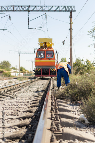 workers replace old wires with new ones in the railway using equipment