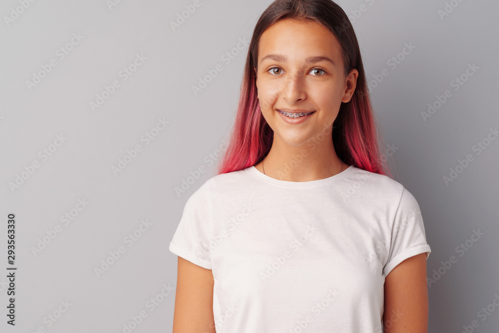 Young girl teenager with pink hair happy and smiling over gray background Young girl teenager with pink hair happy and smiling over gray background