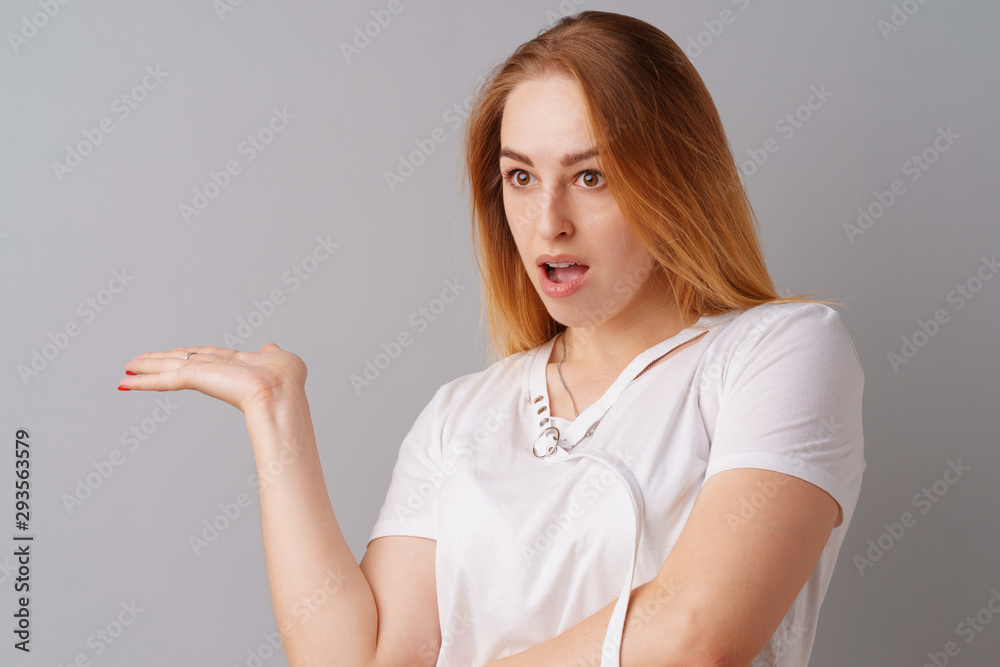 Young beautiful woman portrait being excited and amazed over gray background. Young beautiful woman portrait being excited and amazed over gray background.