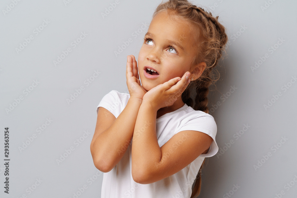 Young beautiful girl kid portrait being excited and amazed over gray background Young beautiful girl kid portrait being excited and amazed over gray background