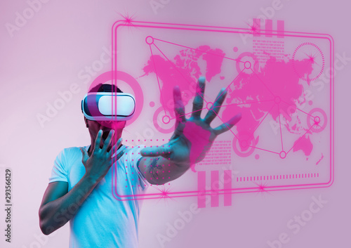 Modern technologies. Young african-american man's touching virtual reality in neon light on pink background. Concept of human emotions, facial expression, modern gadgets and technologies. Copyspace.