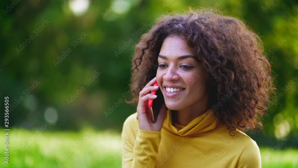 Smiling african talking on mobile phone over green background. Close up beautiful mixed race woman holding and using smart phone. Black female using technology. Smiling african talking on mobile phone over green background. Close up beautiful mixed race woman holding and using smart phone. Black female using technology.