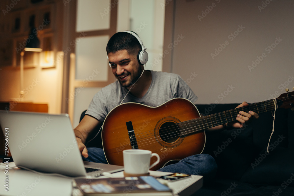 Obraz premium young man practice to play guitar at his home