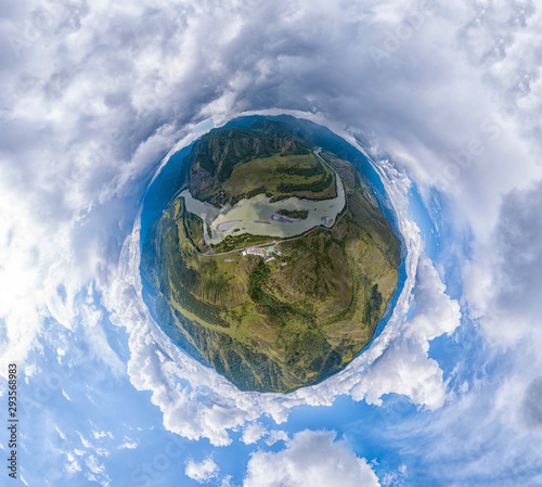 Aerial view of planet earth with the image of nature and picturesque landscapes near a mountain and river on a summer day with white clouds and blue sky.