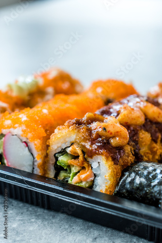 Sushi Set in Plastic Container Box / Package. California Roll, New York Roll, Boom Roll, Ginger, Wasabi and Soy Sauce.