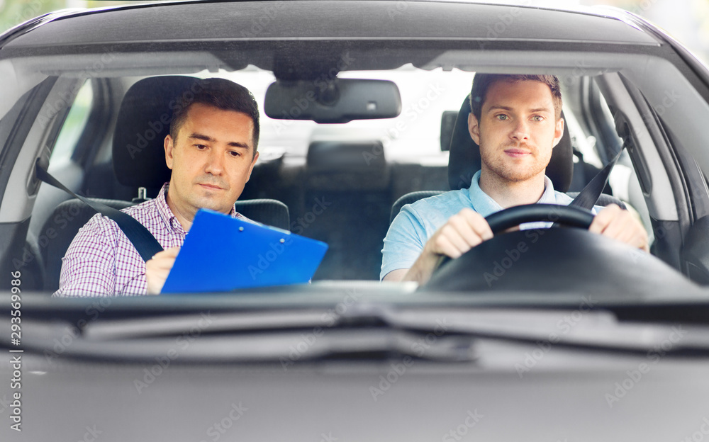 driver courses, exam and people concept - young man and driving school instructor with clipboard in car