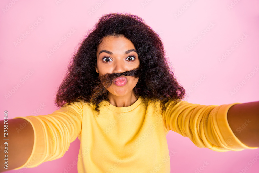 Self-portrait of positive optimistic having fun time girl holding curl of hair with lips taking selfie for her viewers isolated pastel color background Self-portrait of positive optimistic having fun time girl holding curl of hair with lips taking selfie for her viewers isolated pastel color background