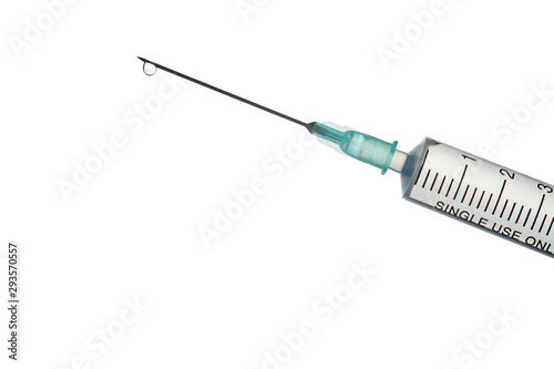 The end of the syringe with a needle filled with liquid on a light background.
