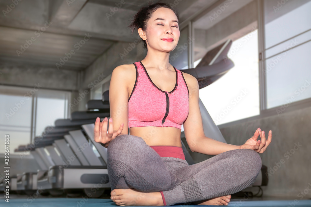 Young Asia woman practicing yoga on gym.Lotus pose on meditation session.