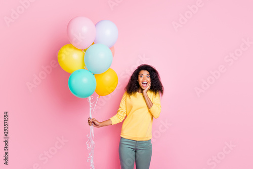 Portrait of excited shocked girl hold many balons get gift for anniversary 8-march impressed scream wow omg wear yellow pullover pants isolated over pastel color background