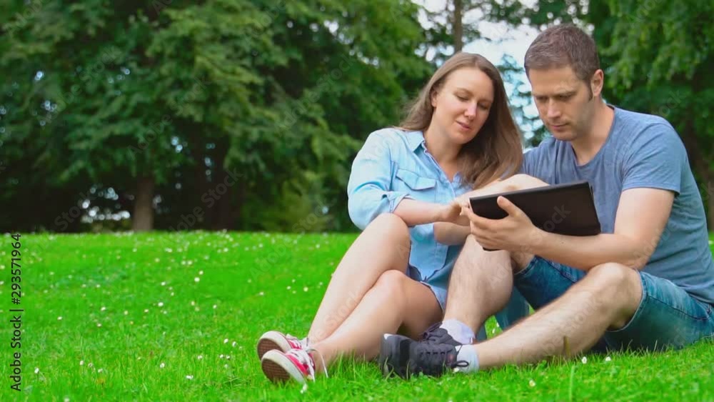 Woman and man using tablet pc in the park. Woman and man using tablet pc in the park.