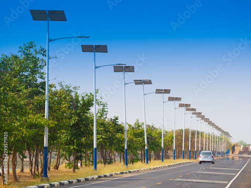 solar street light lamp post led with panel system on the road with green tree and blue sky for background energy saving concept.